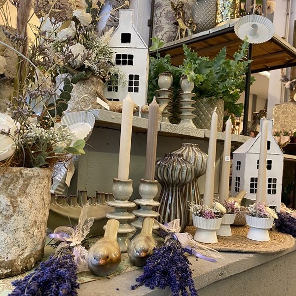 Wohnaccessoires Blühende Pflanzen und Gartenmöbel unter einem Stoffdach.