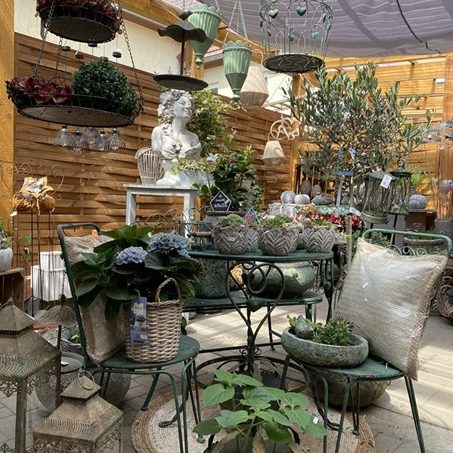 Pflanzen & Gefäße Grüne Keramikvasen und Töpfe mit Katzenmotiven sowie kleinen Pflanzen.